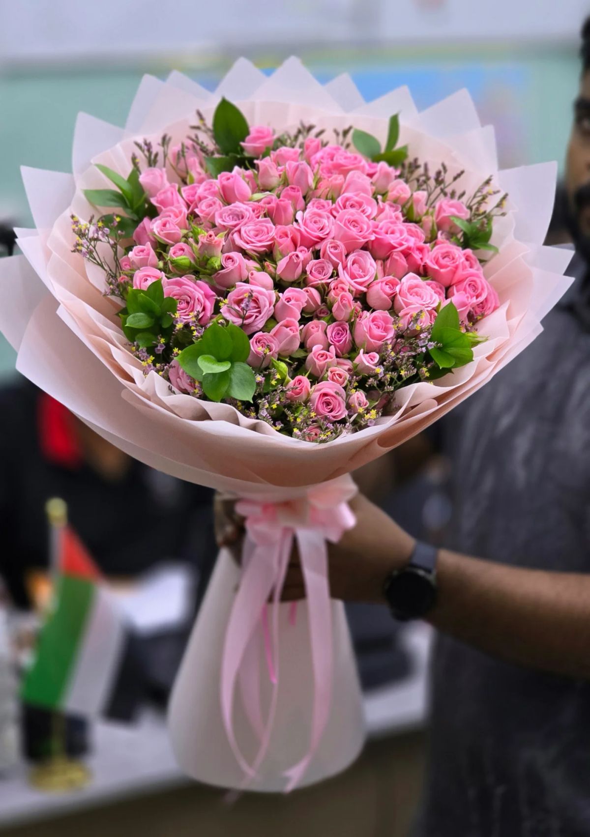 A lush arrangement of vibrant pink roses, carefully styled with delicate greenery and premium wrapping for a sophisticated floral presentation.