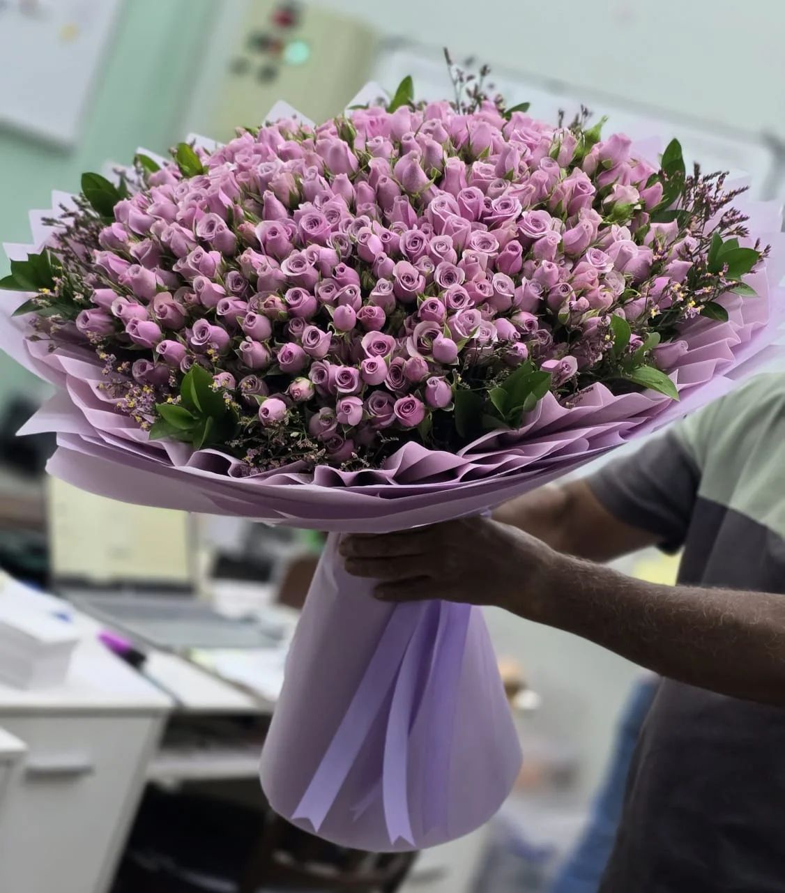 A charming basket arrangement filled with delicate lavender and purple roses.