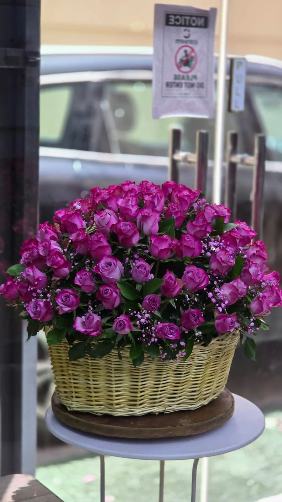 A luxurious basket of beautiful lavender and purple-toned roses.