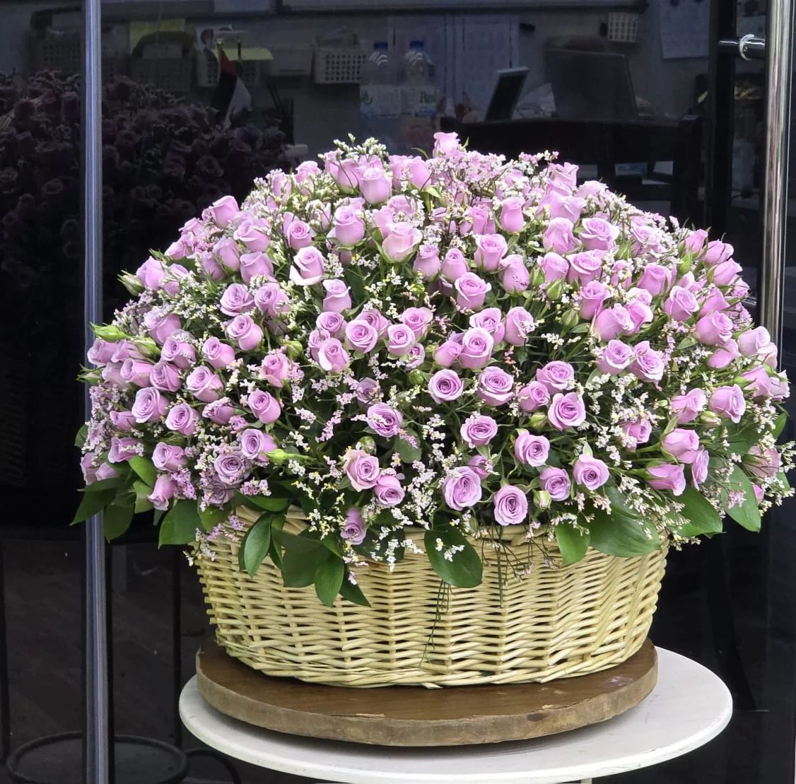 An elegant basket filled with abundant soft lavender-pink spray roses.