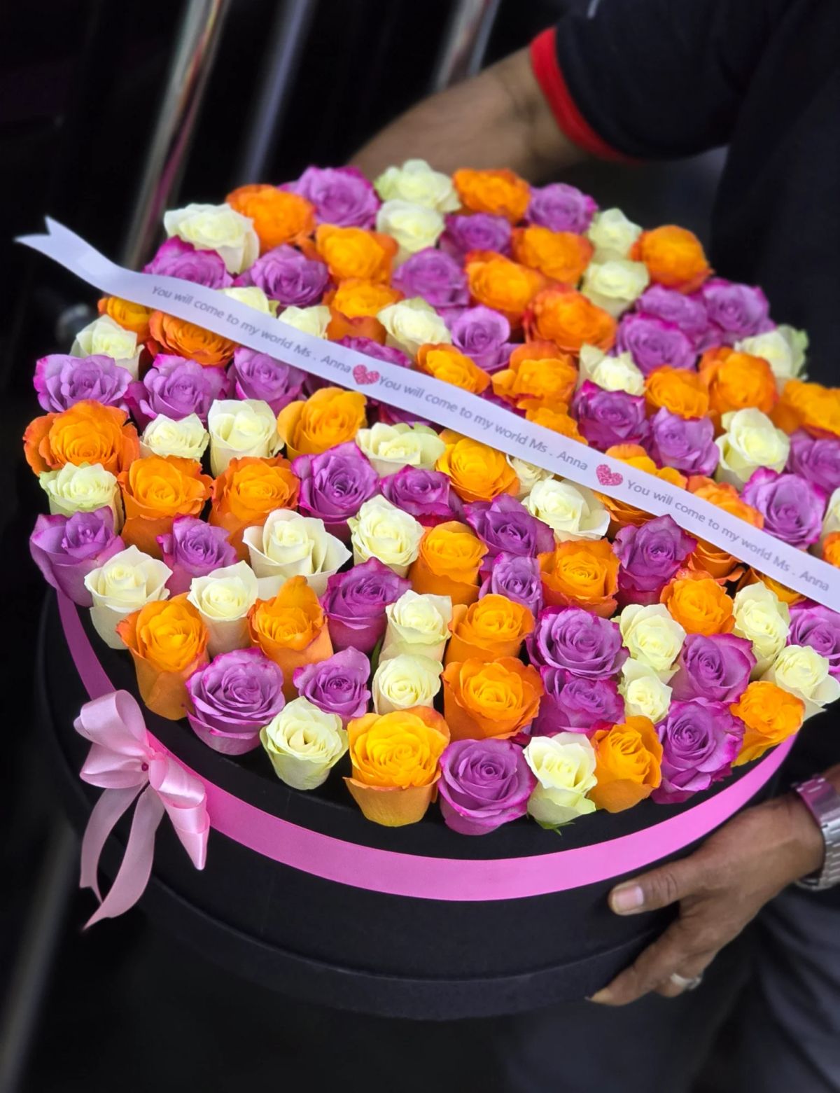 A colorful combination of pink, orange, yellow, and cream roses in a luxury box.