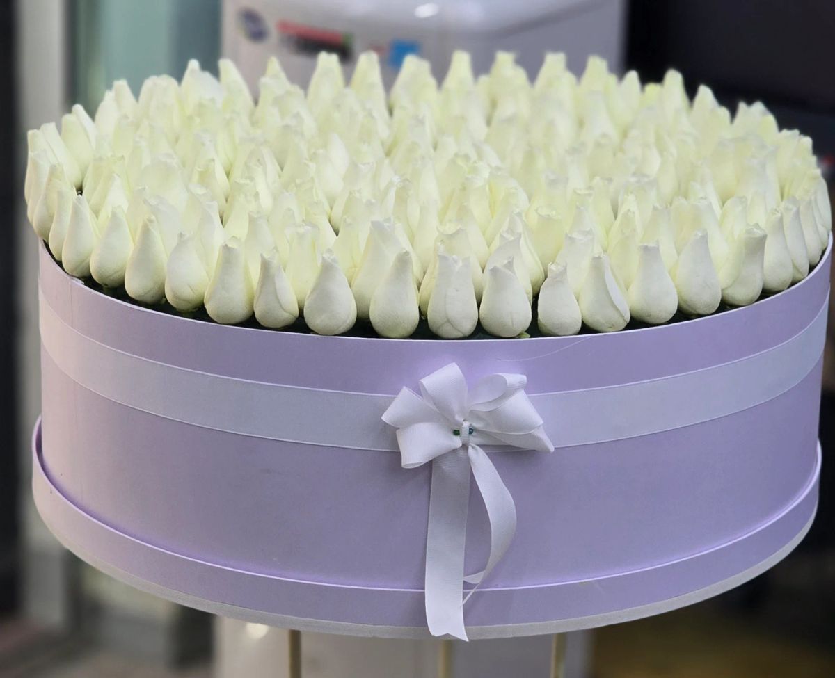A luxurious round box filled with fresh white roses