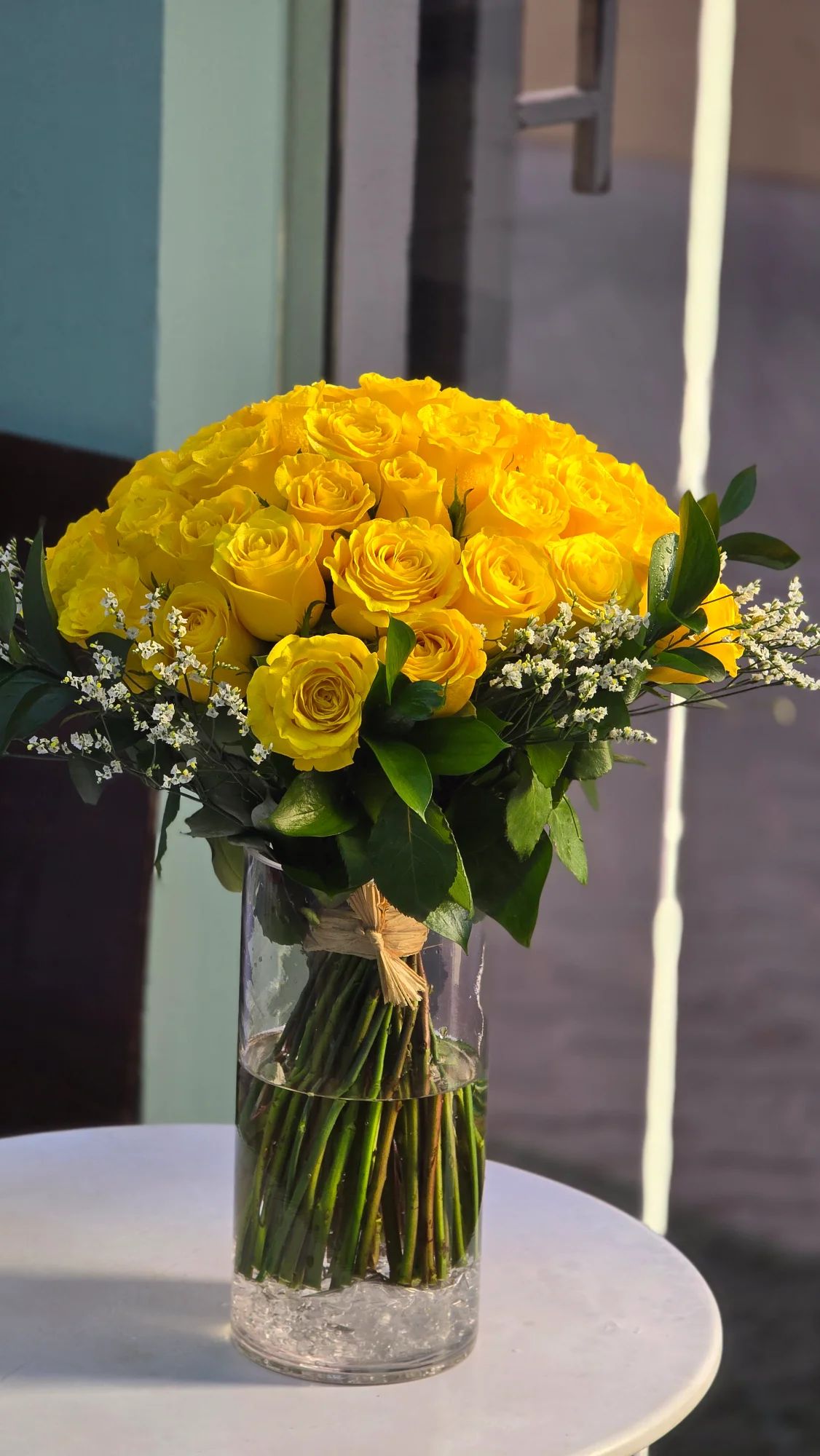 Bright yellow roses arranged beautifully in a transparent glass vase for a cheerful, elegant look.