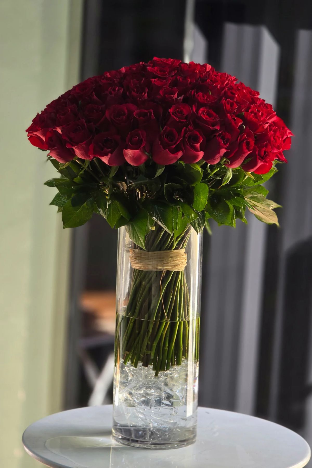 Classic deep red roses arranged in a clear glass vase, expressing love, passion, and elegance.